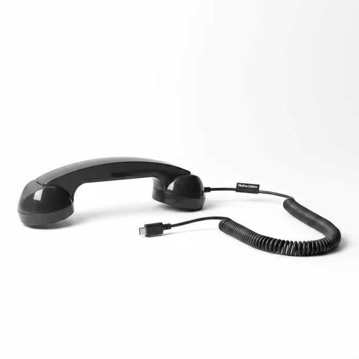 Black telephone handset with coiled cord on a white background