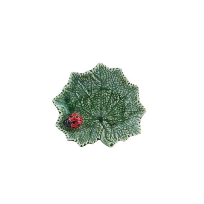 Decorative green leaf-shaped plate with a ladybug on a white background
