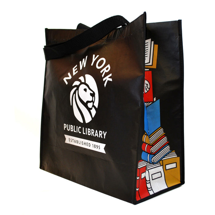 A black reusable tote bag with the New York Public Library logo and a colorful book stack design on the gussets.
