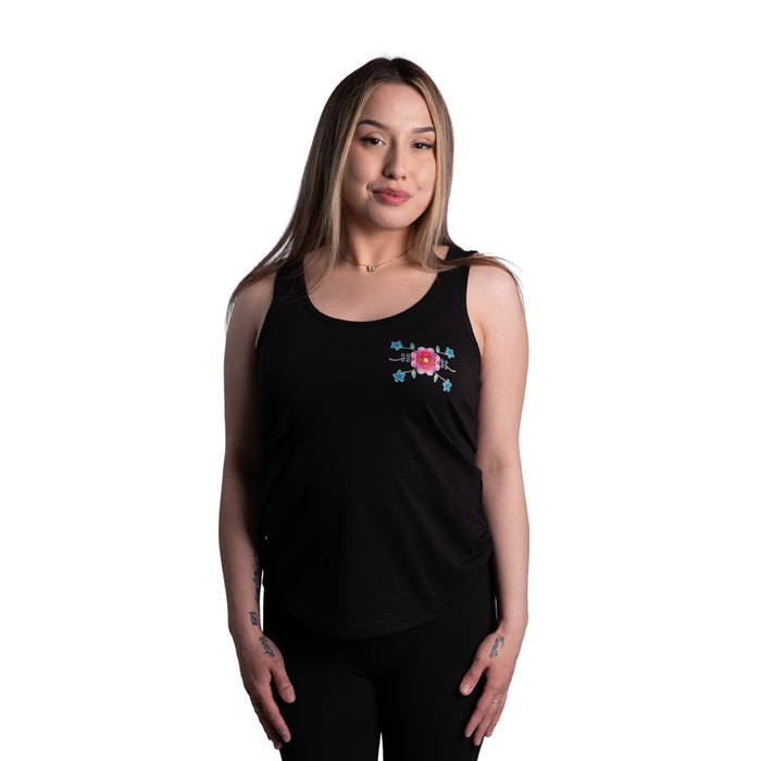 Woman wearing a black tank top with a floral design on a white background