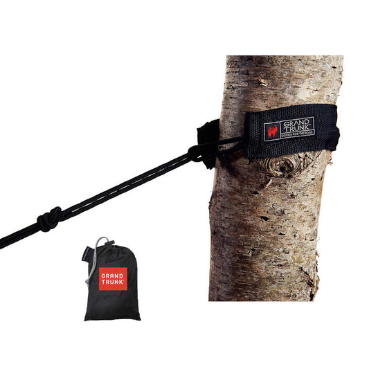 A set of black hammock tree slings attached to a tree, with a stuff sack included.