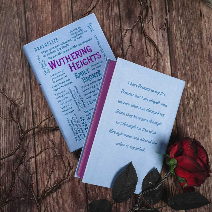 Book titled 'Wuthering Heights' by Emily Bronte on a wooden surface with a red rose.